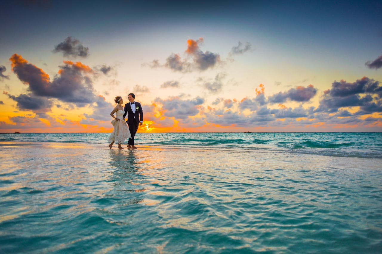 En esta fotografía, vemos una pareja de recién casados paseando por la orilla